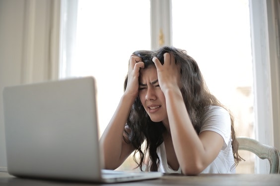 Mujer quejandose frente a una computadora