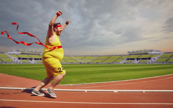 Hombre obeso corriendo en pista de atletismo