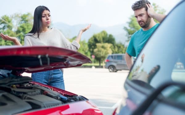 Hombre y mujer discutiendo luego de chocar sus autos