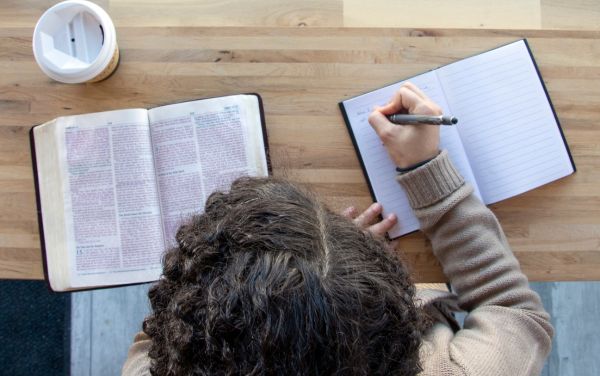 Mujer estudiando y tomando nota de la palabra de Dios