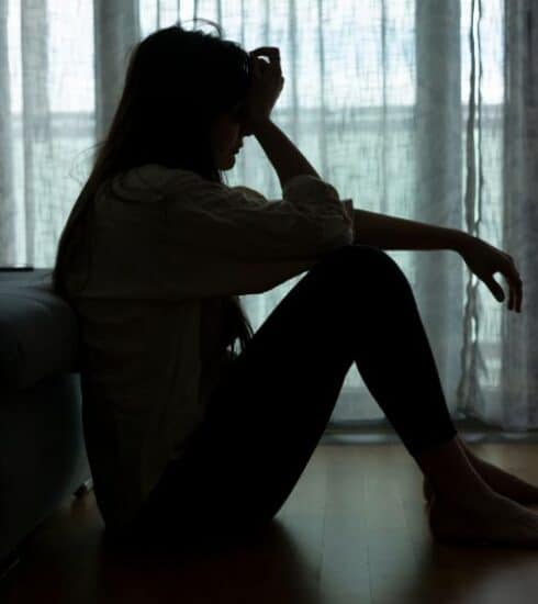 Mujer sentada en el piso con depresión