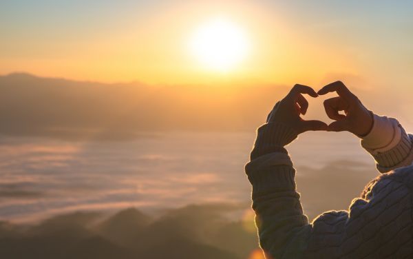 Confianza en Dios, persona haciendo un corazón con las manos hacia el cielo