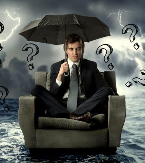 Persona en un mueble sobre el mar bajo una tormenta con un paraguas