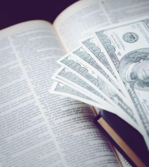 Una Biblia abierta y billetes de cien dolares